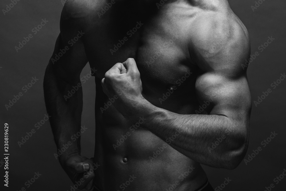 Bodybuilding. Strong man posing on background. Athletic young boy showing muscles. Bodybuilding. Strong man posing on background. Athletic young boy showing muscles.