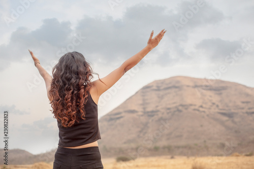 Asian girls spread their hands in the sky to show their happiness and victory with the concept of life and success on the sky in the morning. The silhouette of the girl raised her hand to thank God.