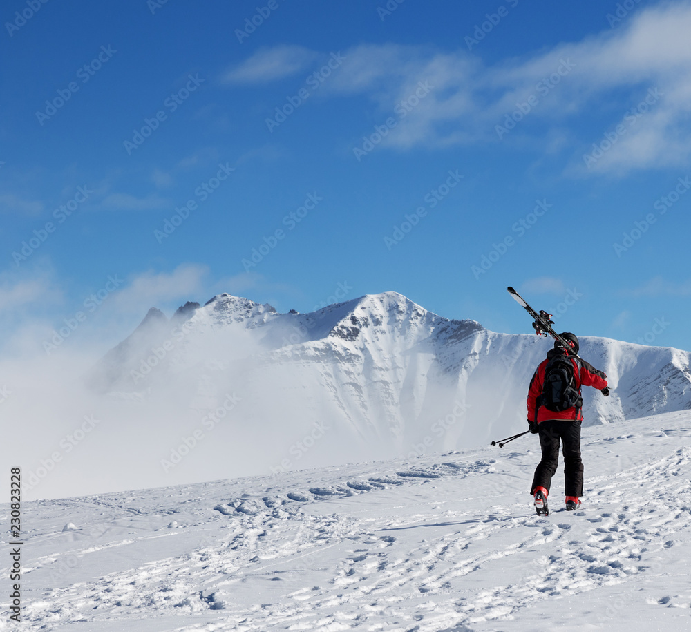 Skier with skis go up to top of mountain