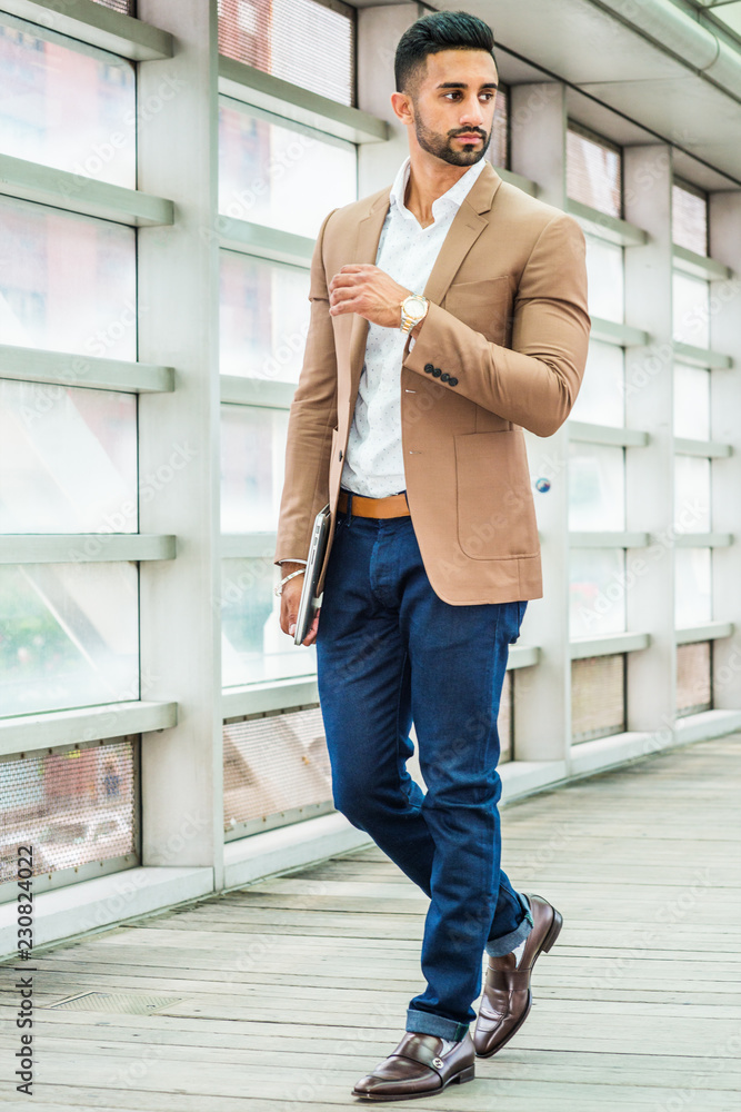 Young Man Business Casual Fashion in New York, with beard, wearing brown  blazer, white shirt, blue pant, black leather shoes, wristwatch, holding  laptop computer, standing inside indoor walkway... Stock-Foto | Adobe Stock