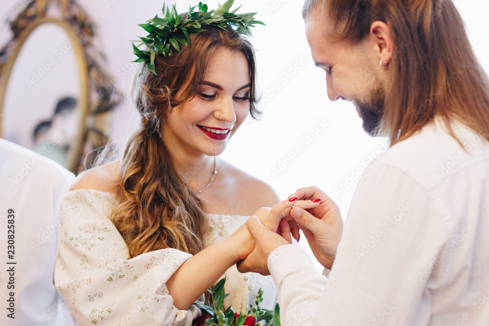 The groom places the ring on the hand The groom places the ring on the hand