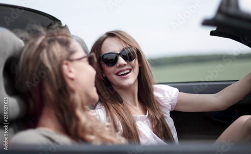 two girlfriends in a convertible car © ASDF