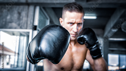 male boxer punching a boxing bag. © FotoArtist