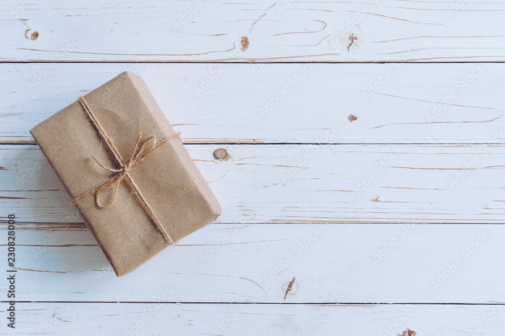 Fototapeta premium Above brown gift box on wooden table background with copy space.
