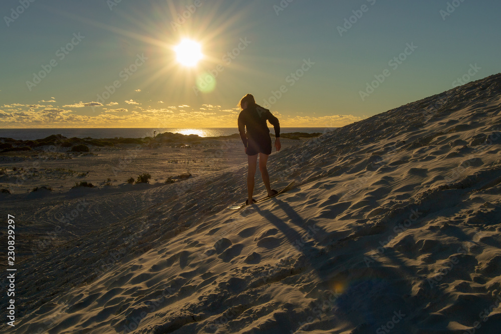Girl surfing the dunes at Lancelin at Sunset