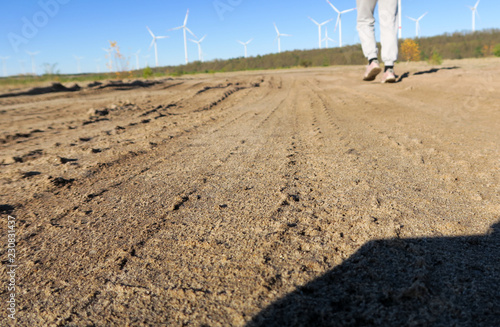 reifenspuren im sand strand mit windrad himmel und jogger photo