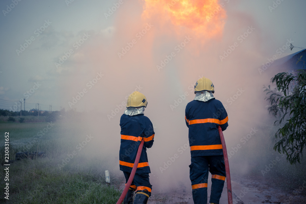 firefighters spraying high pressure water to fire firefighters spraying high pressure water to fire