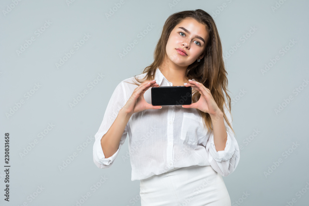 Business woman smiling showing a blank smart phone screen isolated on a white background Business woman smiling showing a blank smart phone screen isolated on a white background