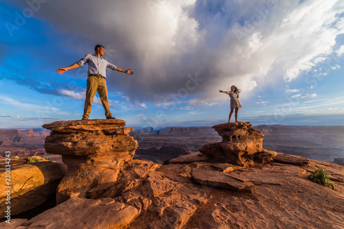 Asian/Vietnamese Bride with White Groom.  Posing for engagement photos on the cliffs in Dead Horse Point State Park.  A vast scenic canyon overlook in the Utah desert, near Moab photo