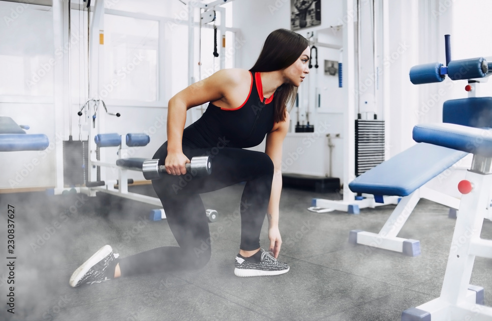 The girl does exercise in the gym The girl does exercise in the gym