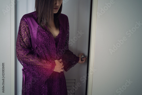 Asian woman in purple long nightwear and lace robe touching belly painful suffering from stomachache causes of menstruation period. photo