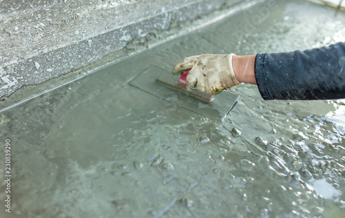 Workers pour concrete solution at a construction site