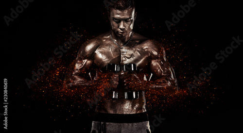 Muscular fitness sports man, atlete with dumbbell in fitness gym. Fire and power.