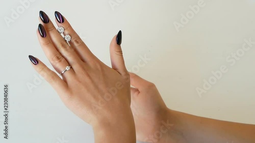 Woman looking at the earrings with diamonds at her hands in the jewelry shop. lady trying on some jewel at the boutique.