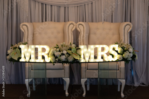 The bride and groom's table at the wedding reception with a Mr & Mrs LED sign