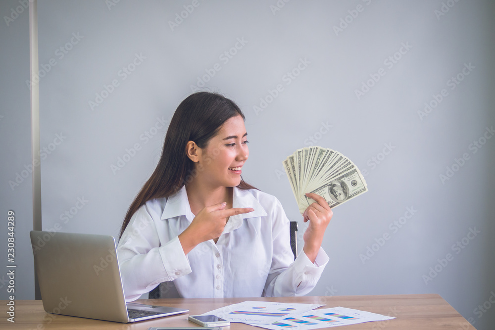 Business woman showing bill of dollars with smiling to successful for work. Business woman showing bill of dollars with smiling to successful for work.
