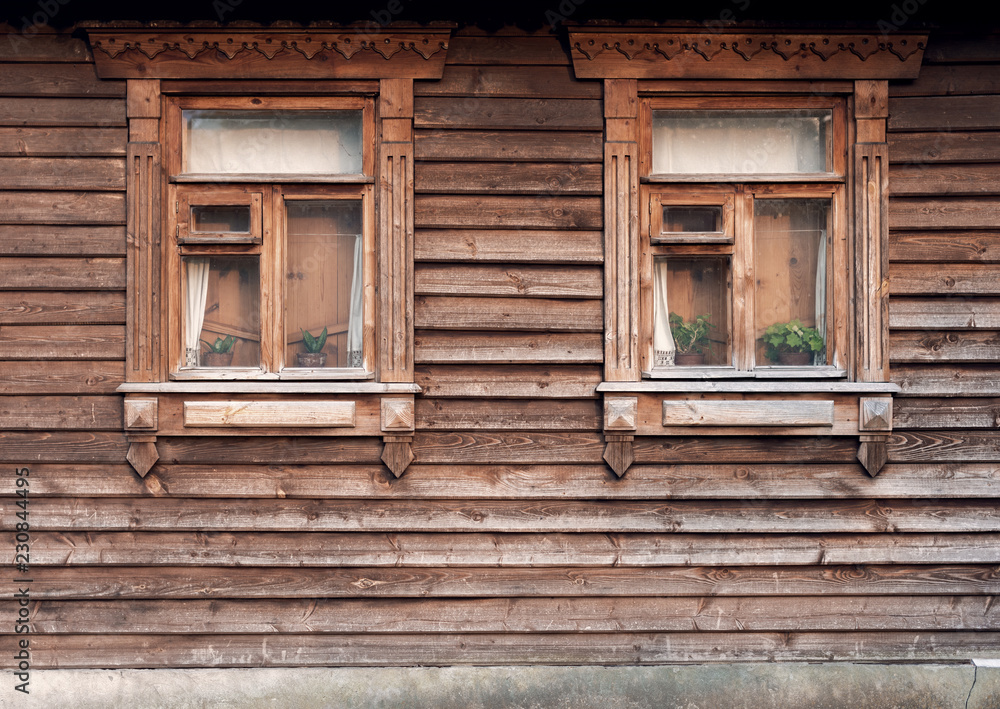 The facade of the old wooden houses with windows The facade of the old wooden houses with windows