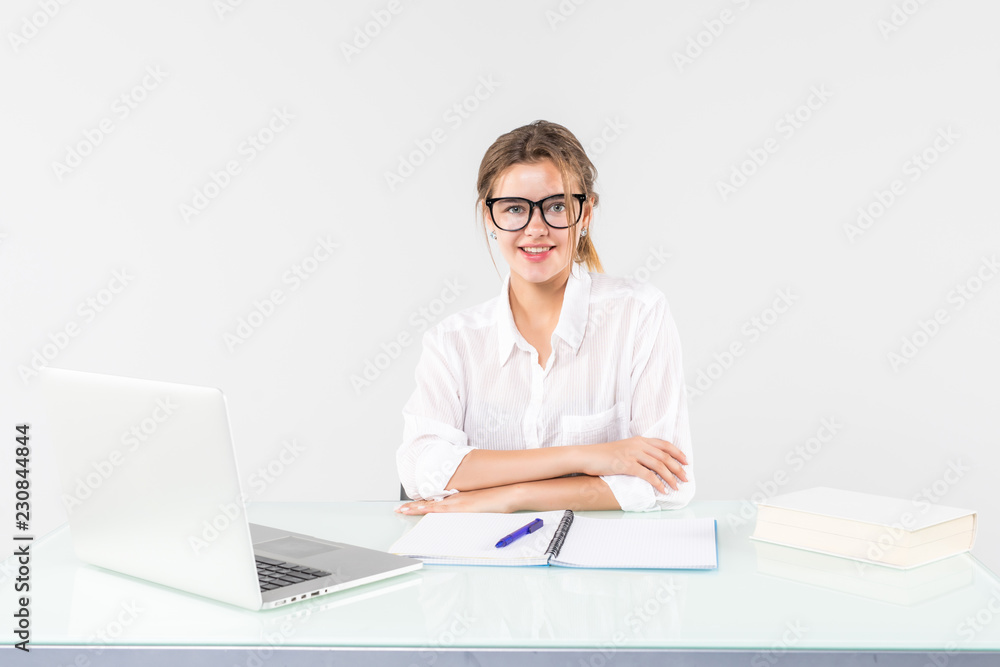 Happy businesswoman sitting at office desk, smiling isolated on white background. Happy businesswoman sitting at office desk, smiling isolated on white background.