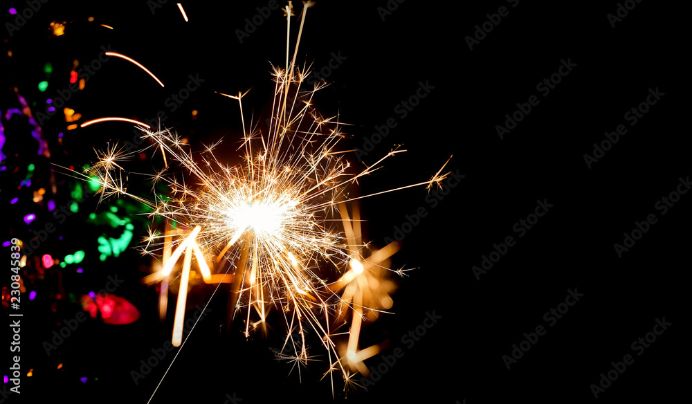 burning Sparkler, bengal light on festive dark abstract blurred background. symbol of party, festival. Christmas, New year holidays. template for design. copy space