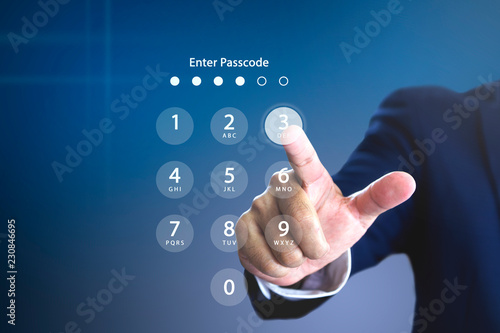 Businessman entering security passcode or password on a virtual login keypad screen to login to an encrypted computerised database system personal account photo