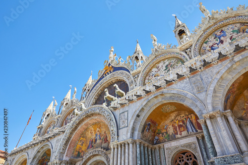 Saint Marck basilica facade low angle view with mosaics in Venice, blue sky in a sunny day in Italy