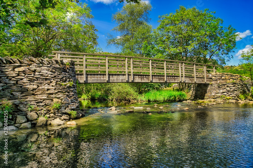 A wooden footbridge crossing a river in the English lake District.