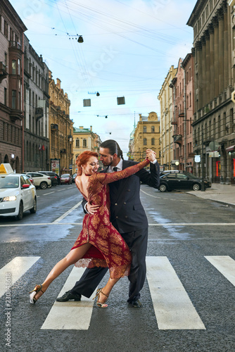 Young, beautiful and professional couple dancing tango on the pedestrian precinct of Saint-Petersburg