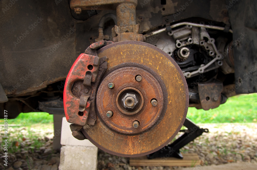 rusty brake disc on a broken car in the yard