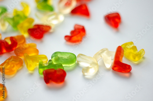 Shiny gummy letters from latin alphabet on a white background