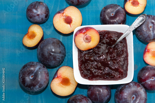 Plums and plummy jam on blue background. photo