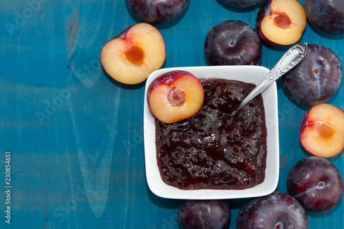 Plums and plummy jam on blue background. photo