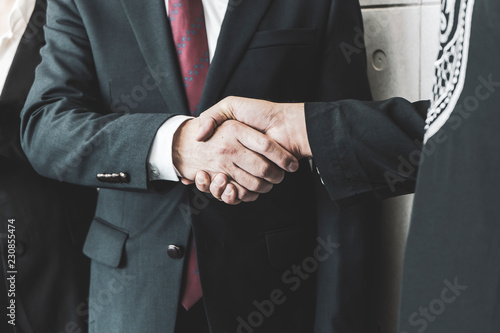 Concept of Negotiating business and handshake Gesturing People Connection Deal. close up hand of business man shaking hands with partner or customer on modern city background,fair play. film tone © Joke Phatrapong