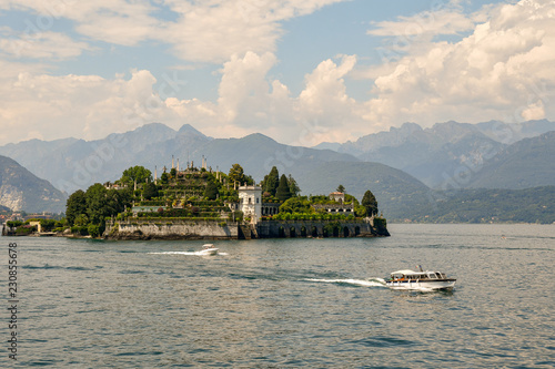 Panorama di un'isola lacustre con barche in navigazione e costa montuosa sullo sfondo, Isola Bella, Lago Maggiore, Italia photo