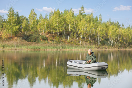 Elderly fisherman fishing from his boat