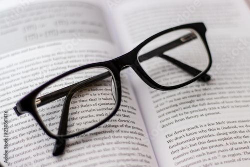 Pair of black glasses lying around on white background