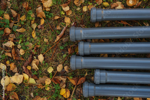 Plastic pipes for water supply and sewage on the ground prepared for installation. 