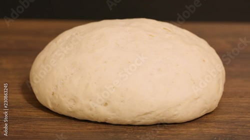 time laps. the dough rise . yeast dough rising on wooden table, on dark background. stages of cooking pizza or bread. pizza dough. raw 4k photo