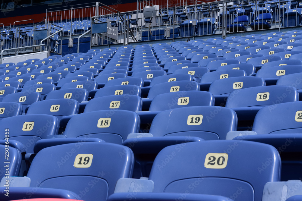 Naklejka premium Empty rows and sections of red and blue seats in a sports stadium.