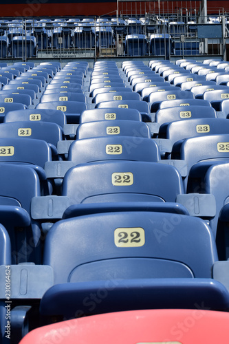  Empty rows and sections of red and blue seats in a sports stadium.