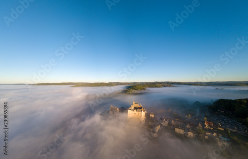 Chateau Beynac in fog in the early morning Perigord Noir Dordogne France