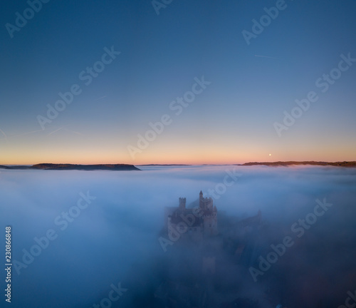 Chateau Beynac in fog in the early morning Perigord Noir Dordogne France