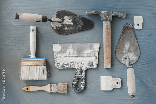 Kit of putty knives. Spatulas with the remaining mortar. Gastarbeiter or guest worker concept. photo