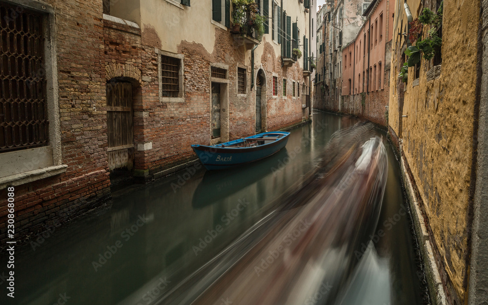 View on small canal in Venice with passing by gondola