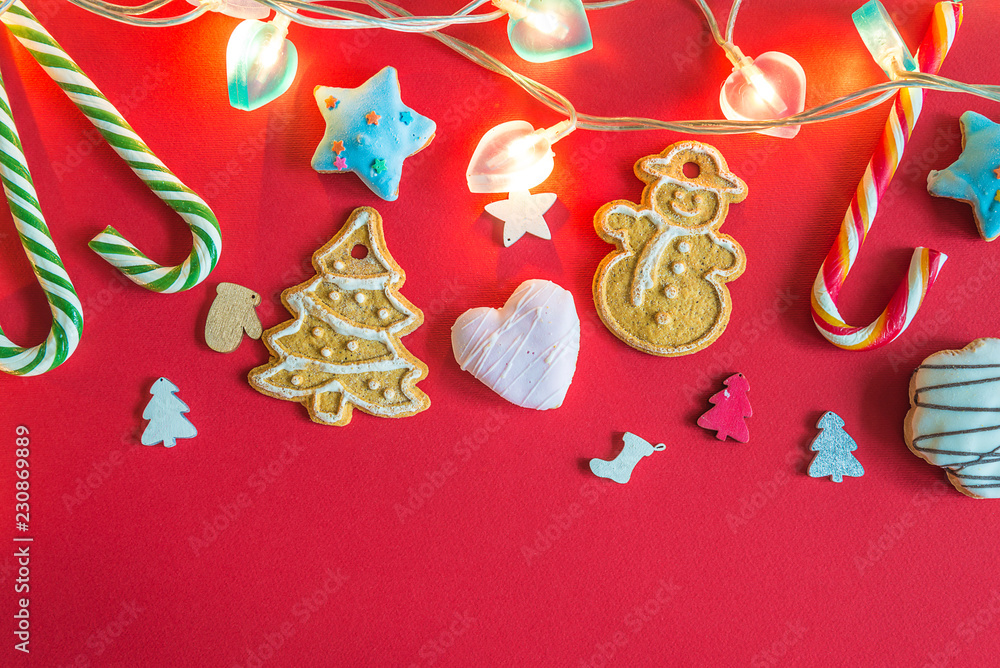 Beautiful christmas decorations with cookies and lights on red background with copy space