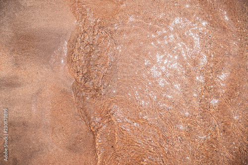 Wellen am Sandstrand als Hintergrund - Textur