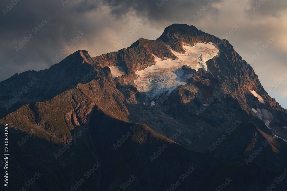 Sunset light shines on peak of mountain Roche de la Muzelle