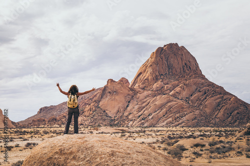 Jeune femme aventurière Randonneuse devant montagne Spitzkoppe en Namibie Afrique