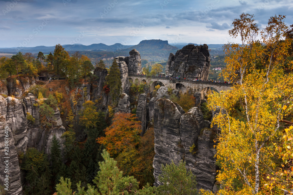 Amazing autumn  landscape in Saxony Bastei Mountains national park. View Exposed sandstone rocks and  forest hilly at sunset. Concept of outdoor recreation in natural settings out of town. 
