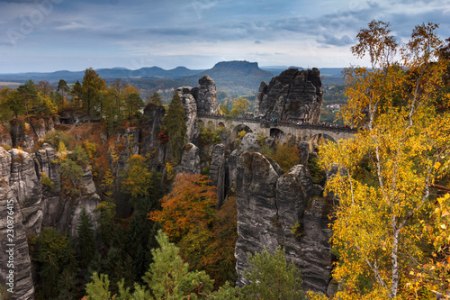 Amazing autumn landscape in Saxony Bastei Mountains national park. View Exposed sandstone rocks and forest hilly at sunset. Concept of outdoor recreation in natural settings out of town. 