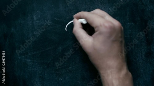 Hand writes with chalk 